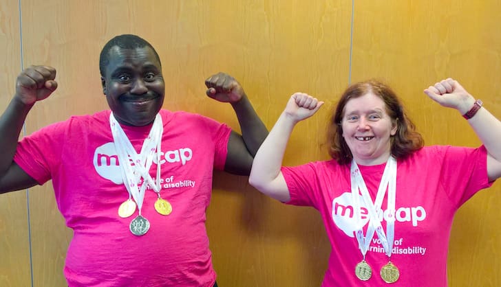 Two people wearing medals and pink shirts