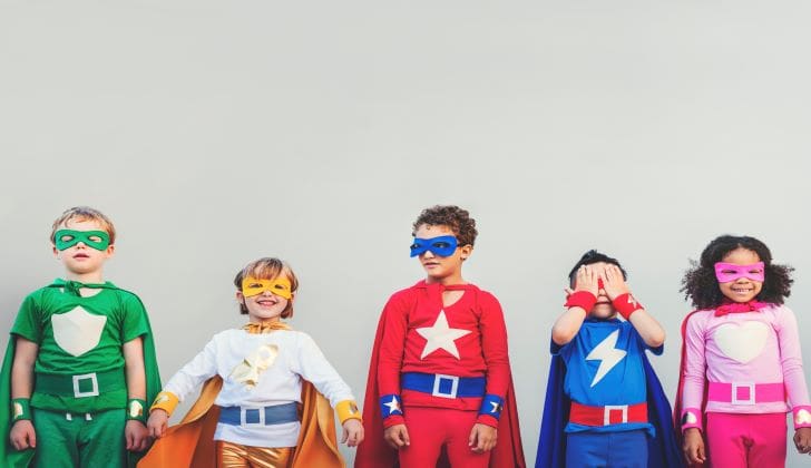 Three children dressed as superheroes standing next to each other.