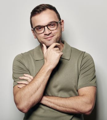 A man with glasses is posing for the camera.